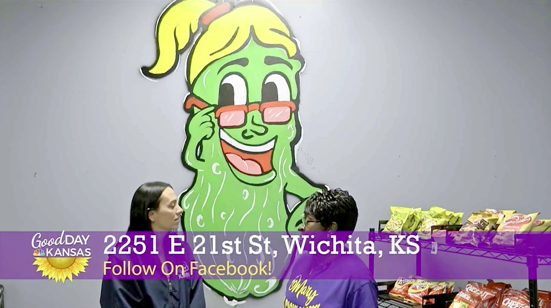 Good Day Kansas filming inside Merry Tastie Snack Shop at 2251 E. 21st St in Wichita, with the pickle mascot on the wall behind