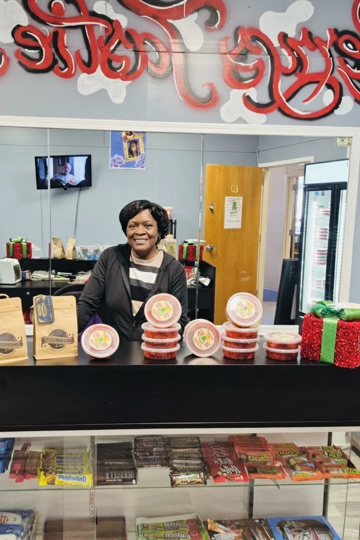 Miss Merry behind the counter at her Wichita snack shop on East 21st, with cups of flavored pickles on the counter